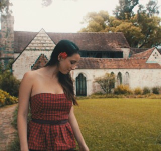 color-grading-model-standing-in-front-ofstone-house